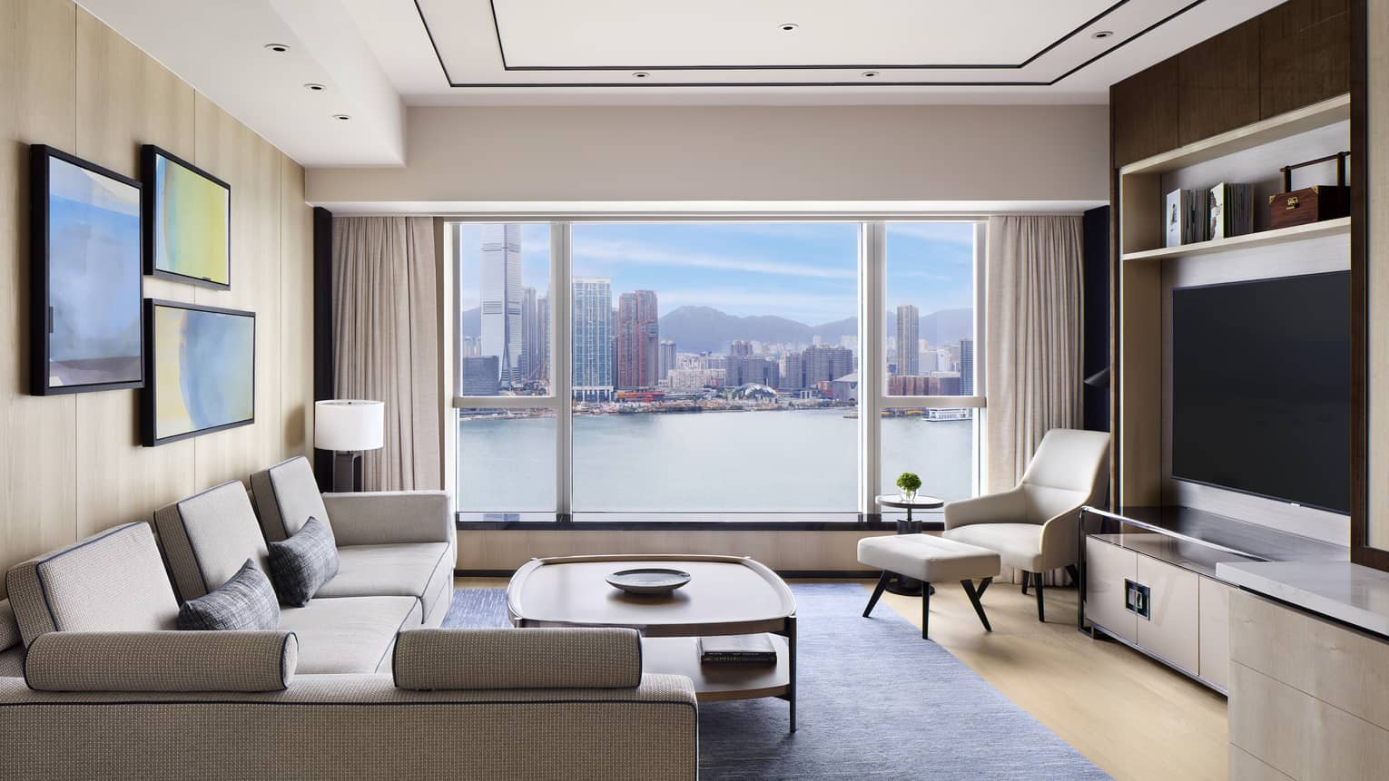 Contemporary living room with large window overlooking city harbour