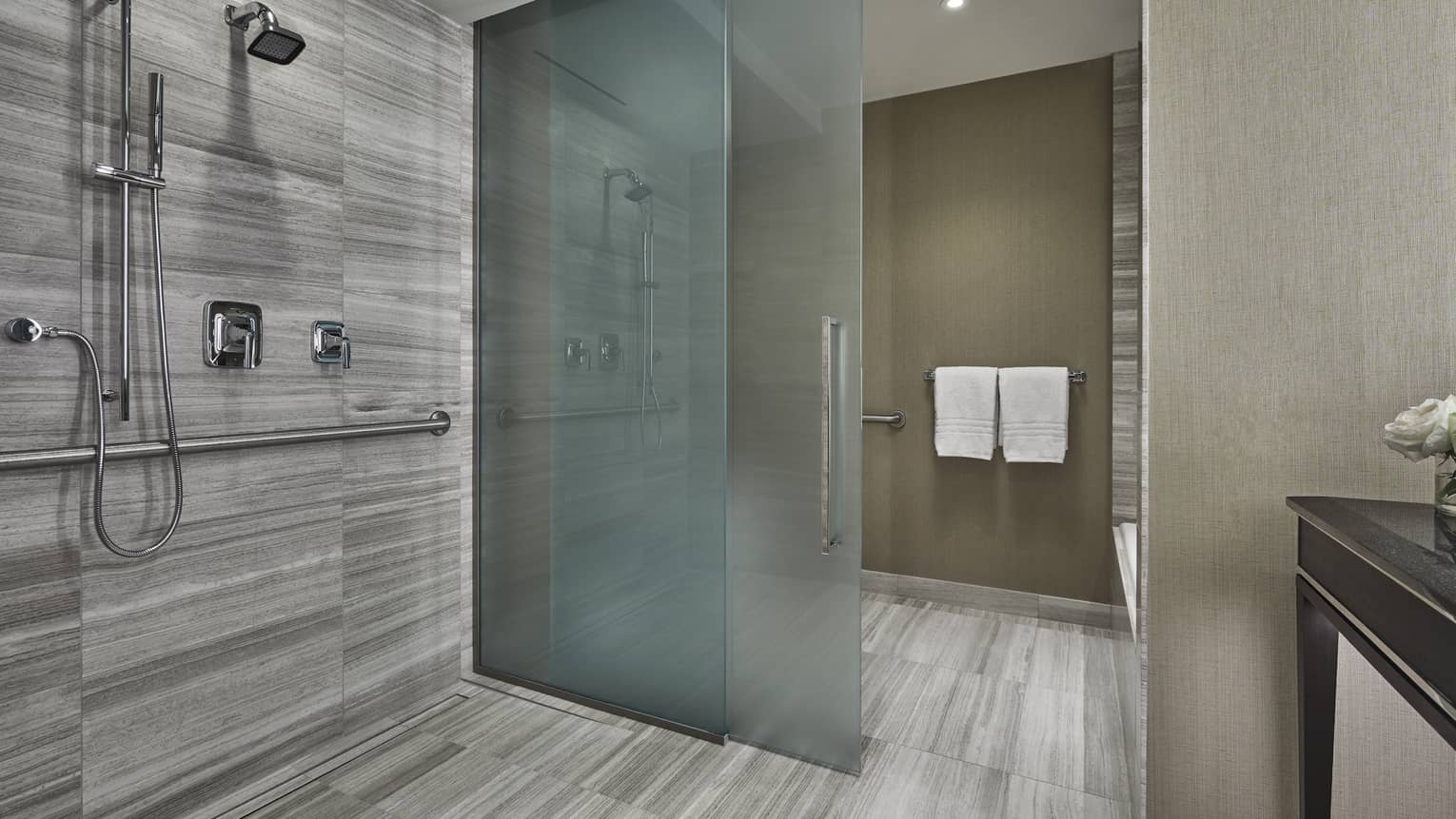 A large wet bathroom opens up into a four seasons hotel boston one dalton room. 