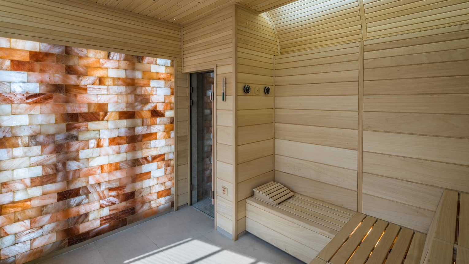The Club wood sauna room with illuminated wall with wood, brick pattern