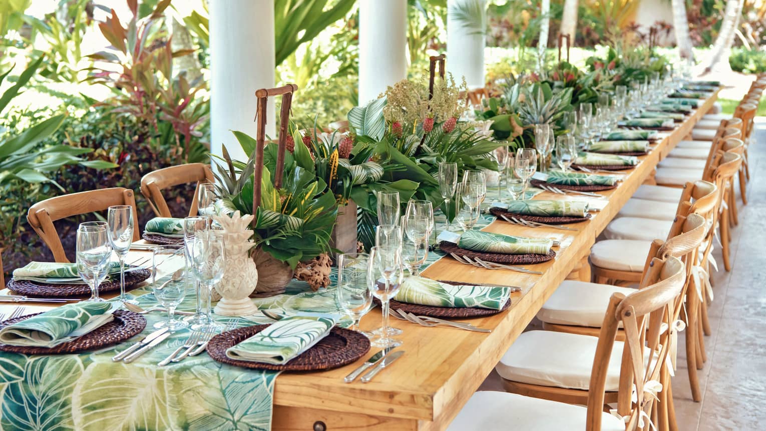 Versailles outdoor terrace with a set table with a green leafy runner and napkins 