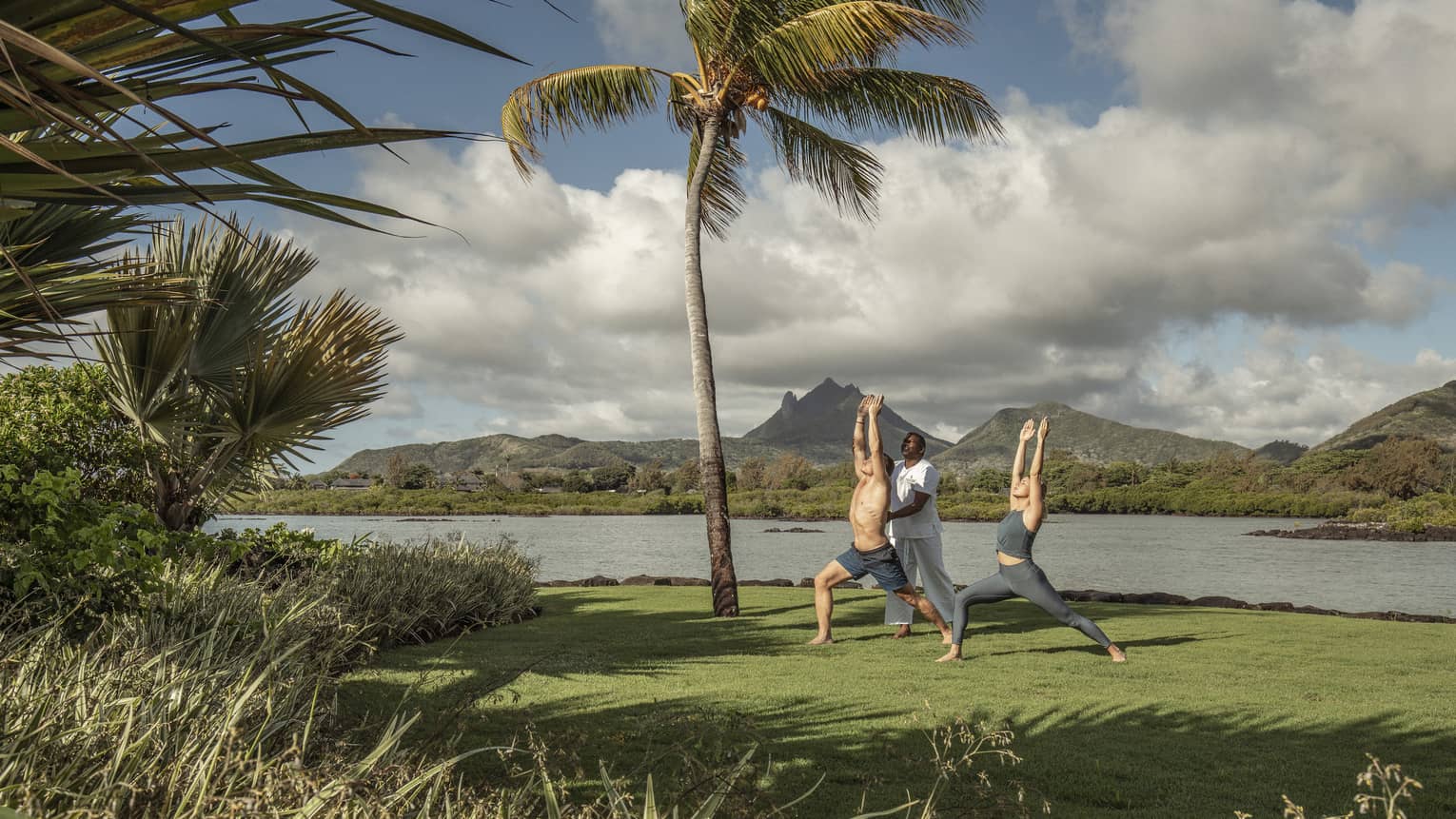 Yogi teaches a couple oceanfront yoga