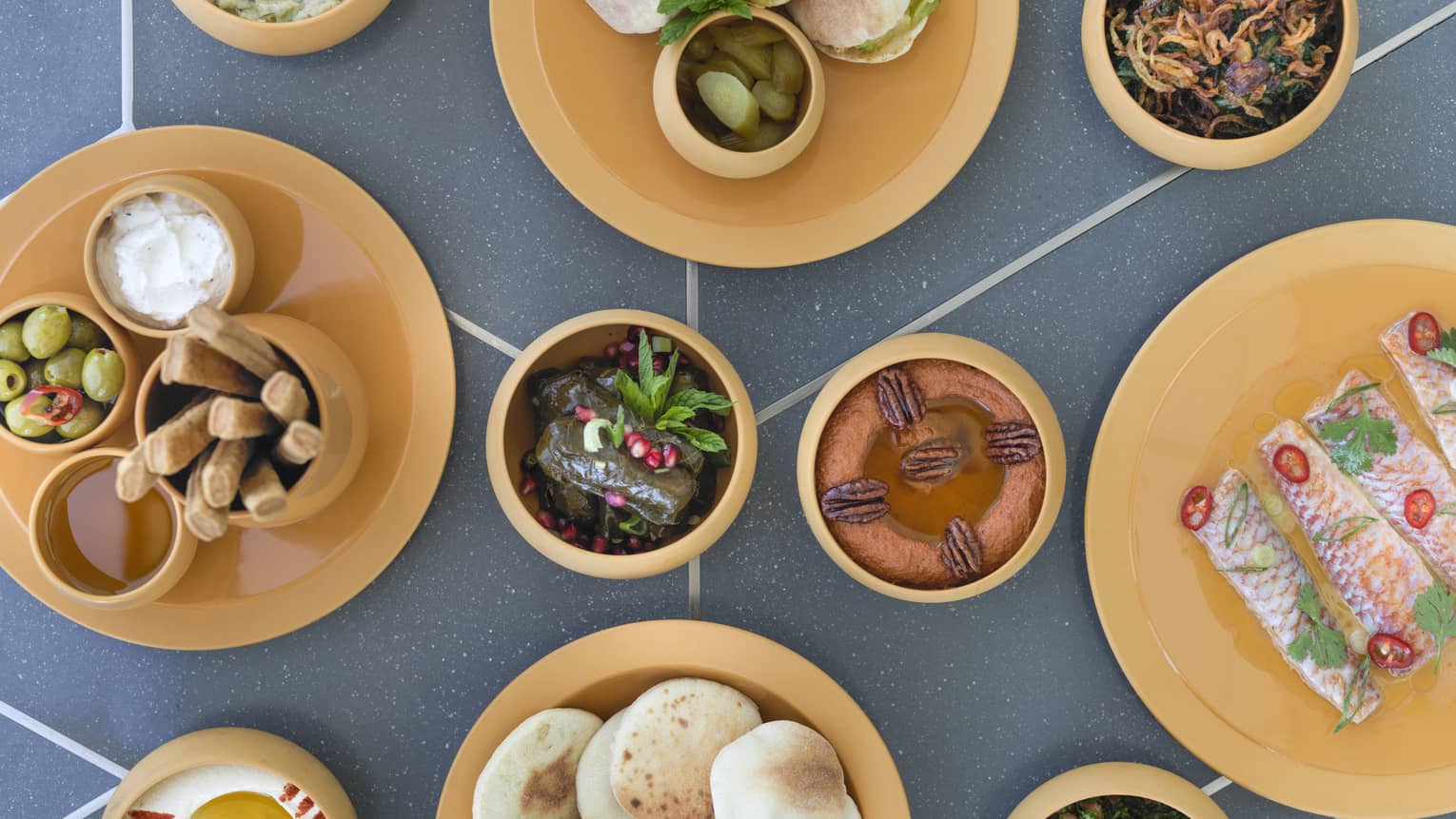 Aerial view of table with small bowls with hot and cold Lebanese mezze dishes 