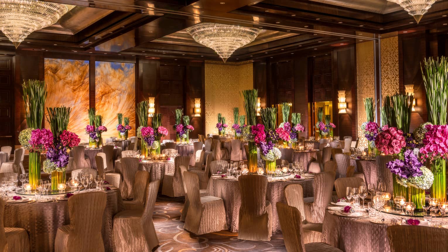 Imperial Ballroom wedding reception with fabric-covered chairs, floral centrepieces, crystal chandeliers