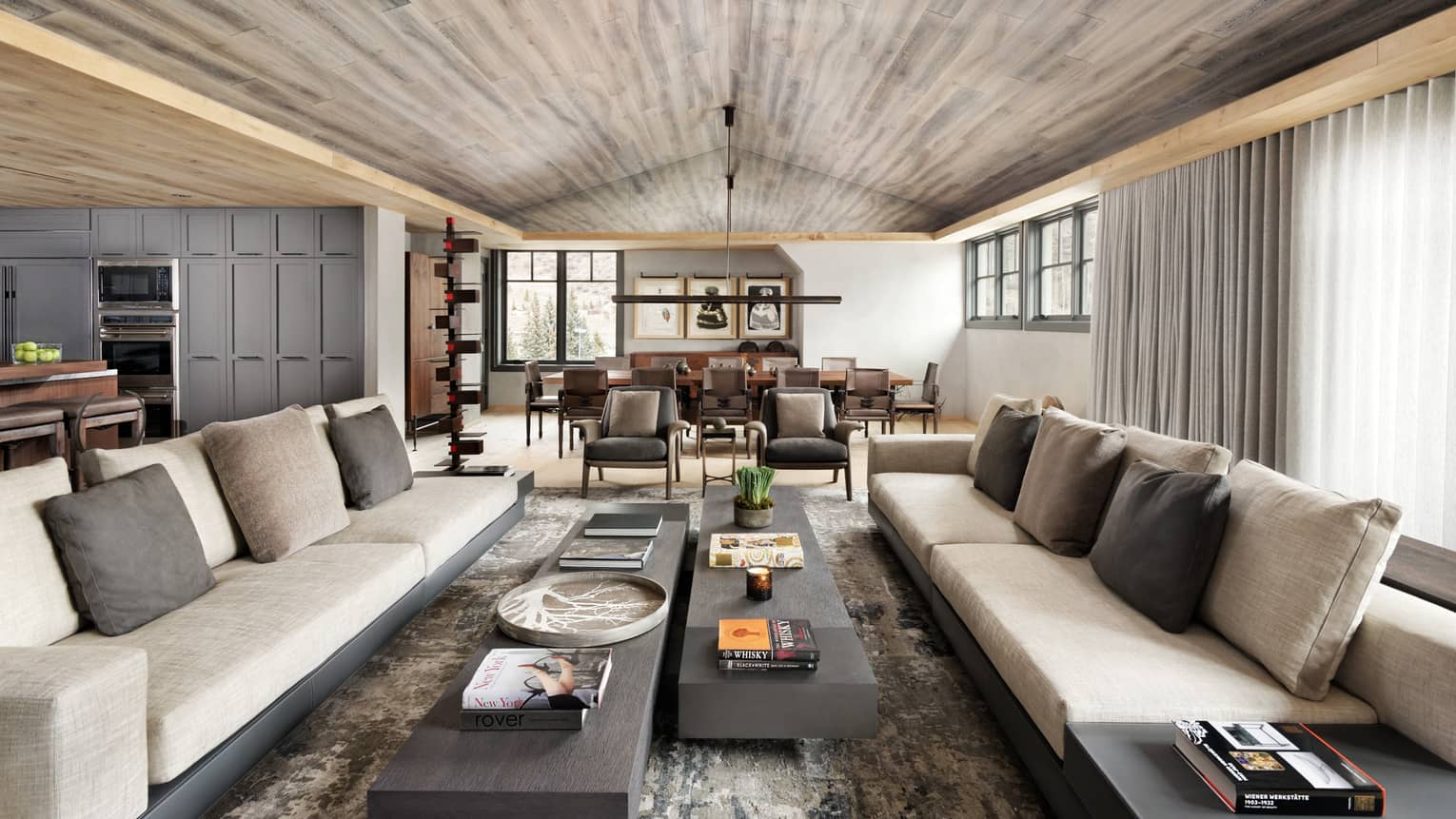Long beige sofas, two slate coffee tables under wood ceiling