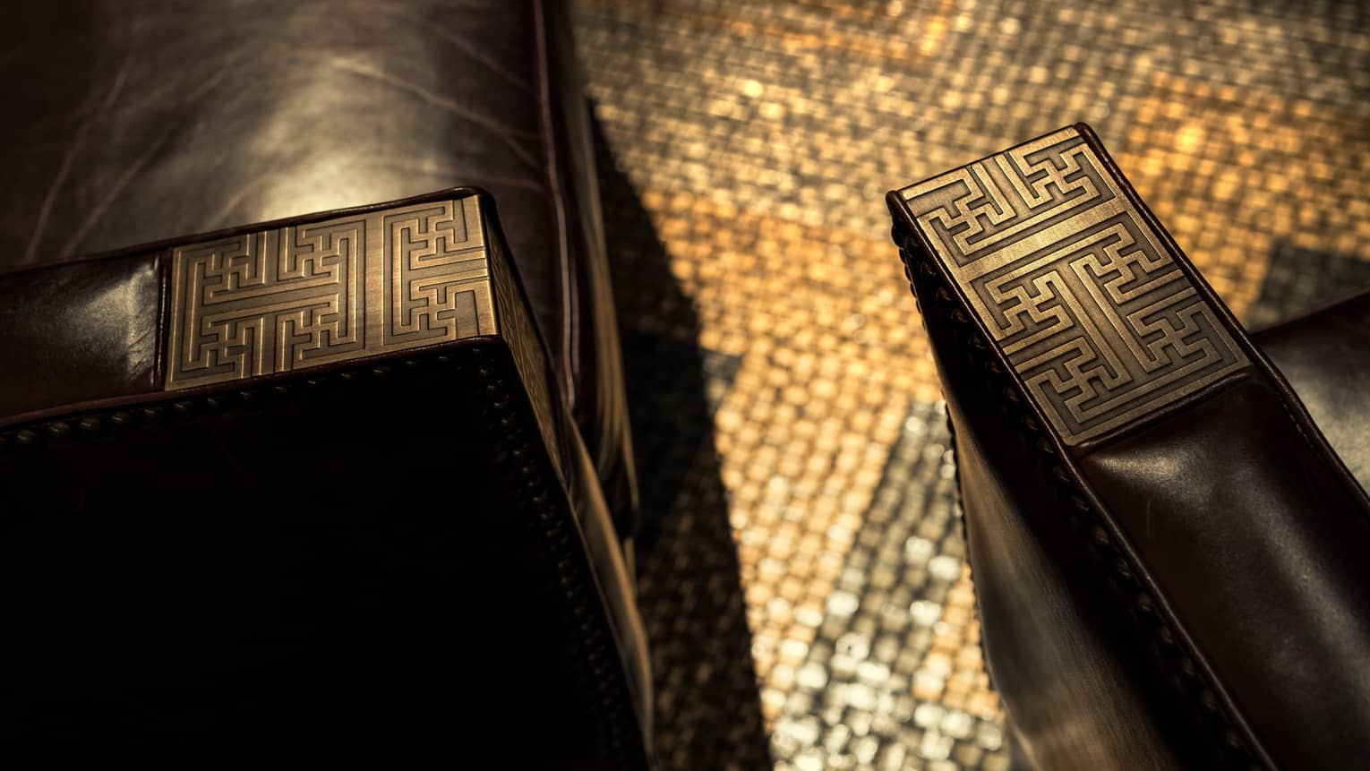 Decorative carved wood details on arms of leather chairs in Charles H lounge