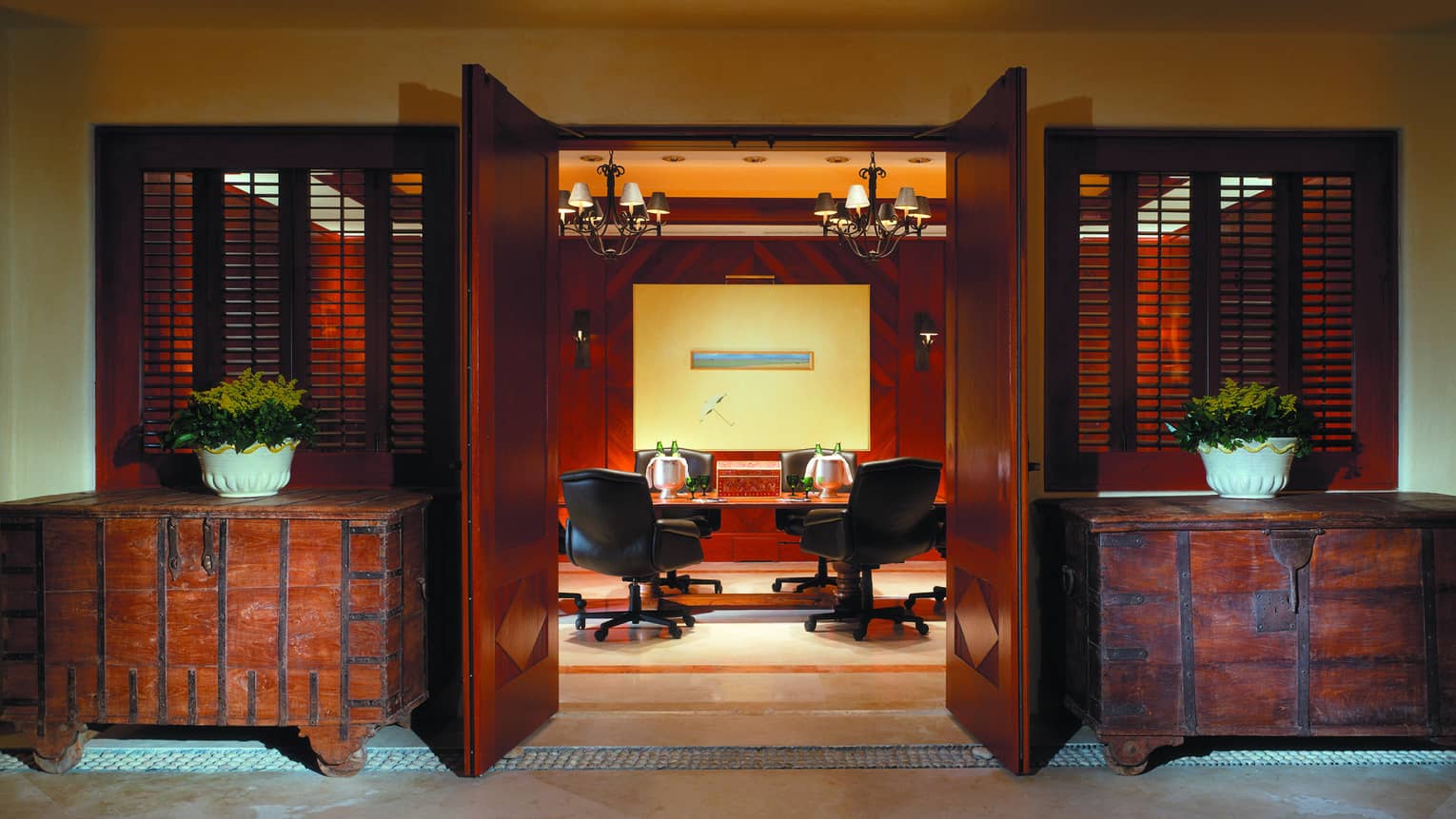 Rustic trunk cabinets flank open doors to Tau meeting room, table