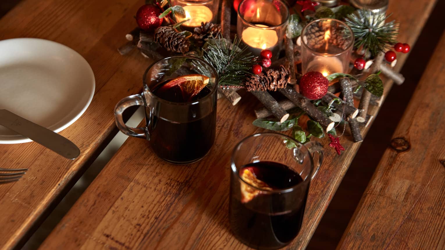 Beverages next to a festive table centerpiece with candles.