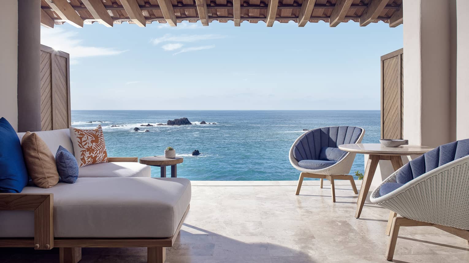 Sitting area with two chairs and one sofa, opening to the sea