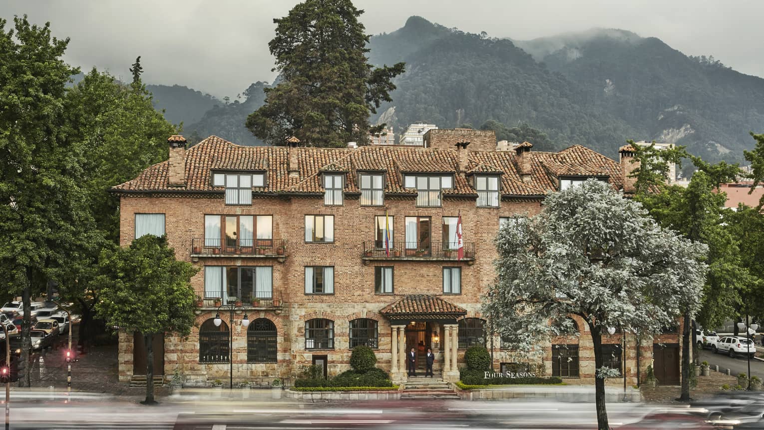 Exterior of historic brick Four Seasons Hotel Bogota, Casa Medina hotel, mountain in background