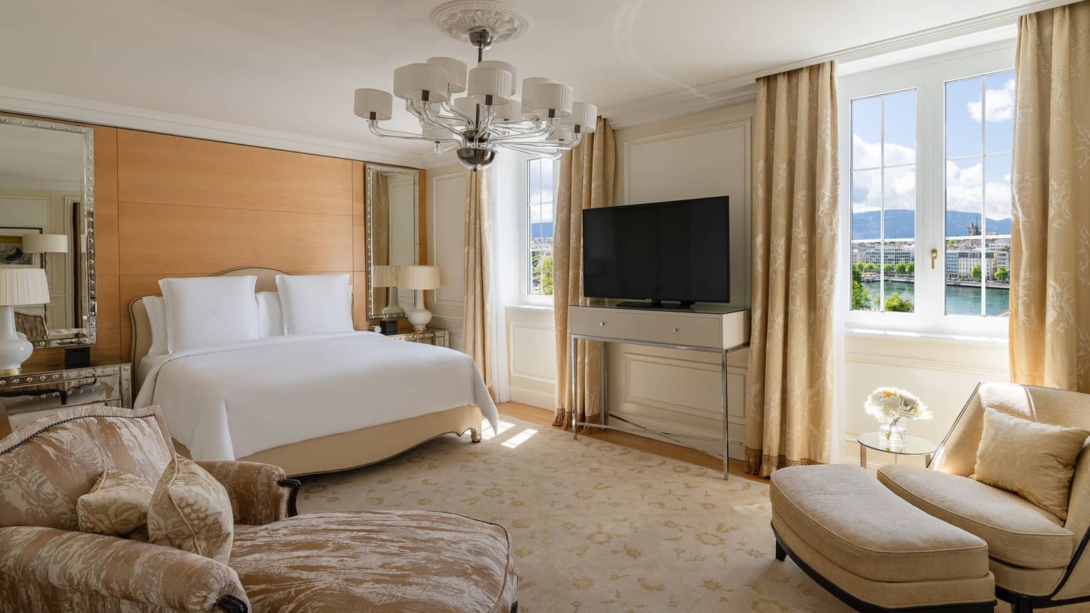 Luxury suite bedroom with king bed, chaise and arm chair at Four Seasons Hotel des Bergues, Geneva