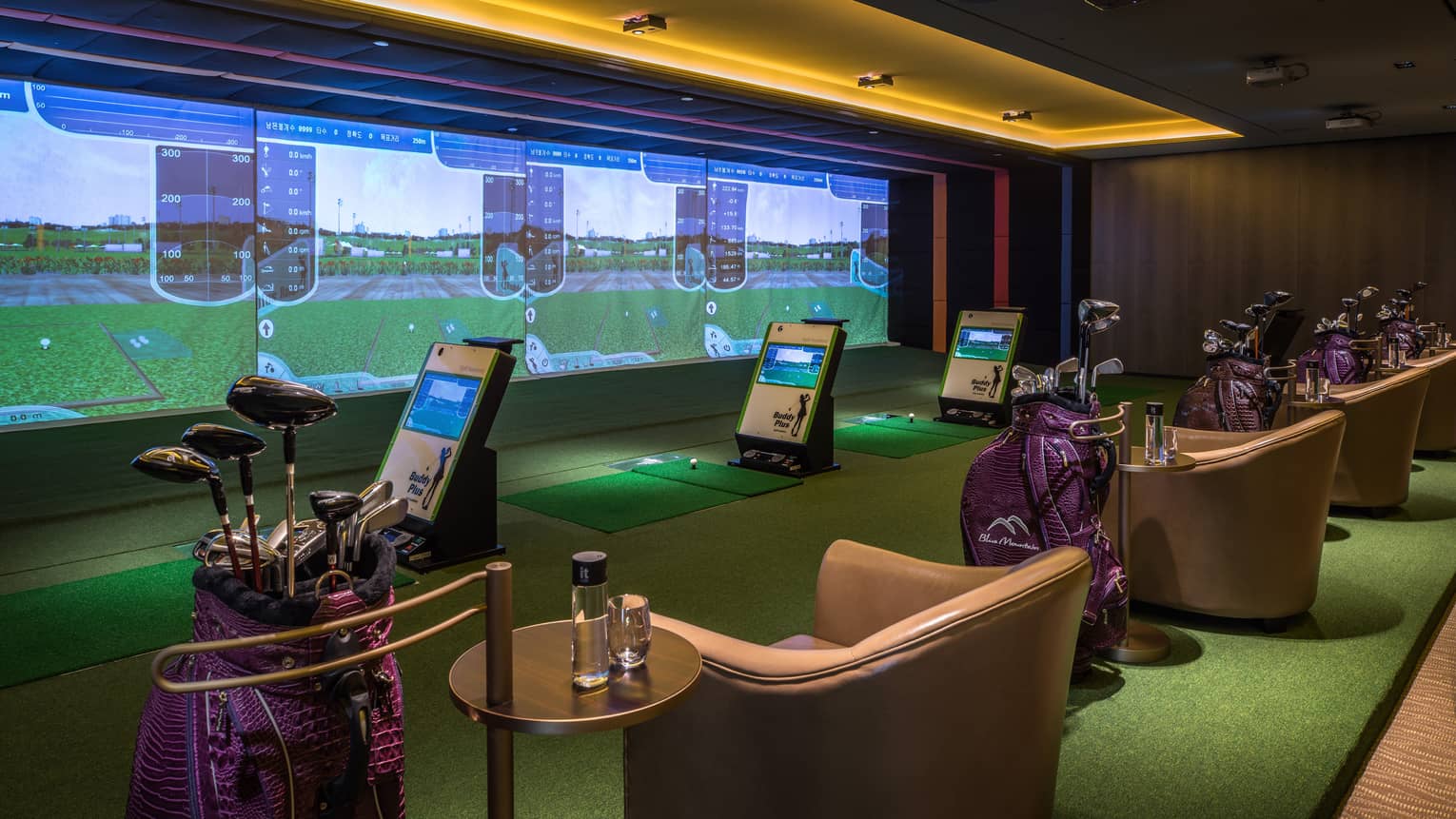 Wall with animated screens, 3D golf course game centre, armchairs with water bottles