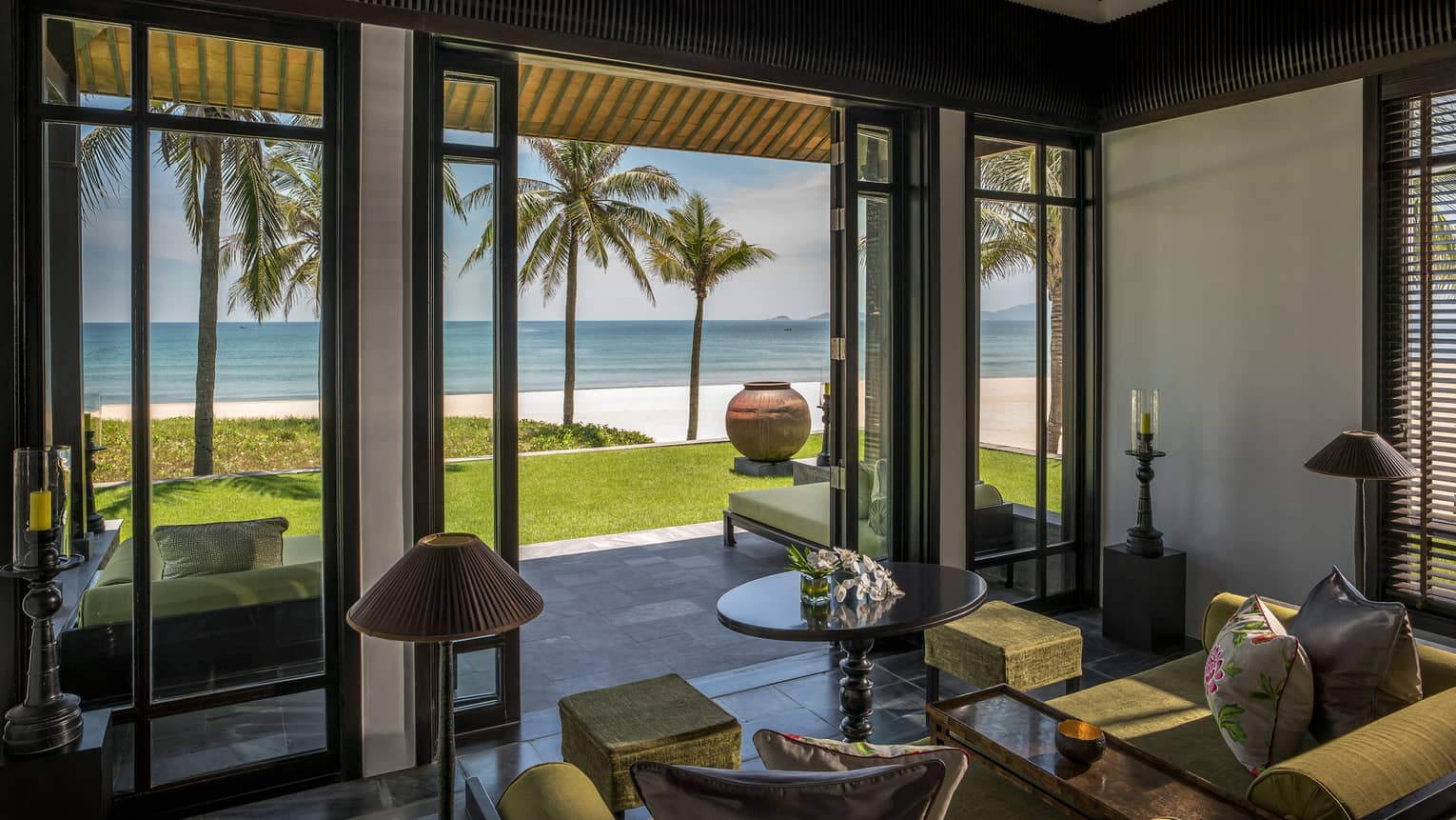 Beachfront Villa living room with open walls to lawn, palm trees, beach, ocean