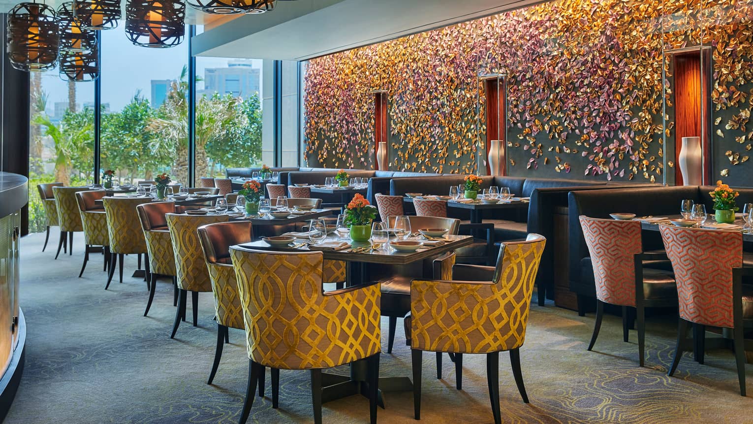 Bahrain Bay Kitchen elegant indoor dining room with chairs with gold details, formal dining tables, flower-petal mural