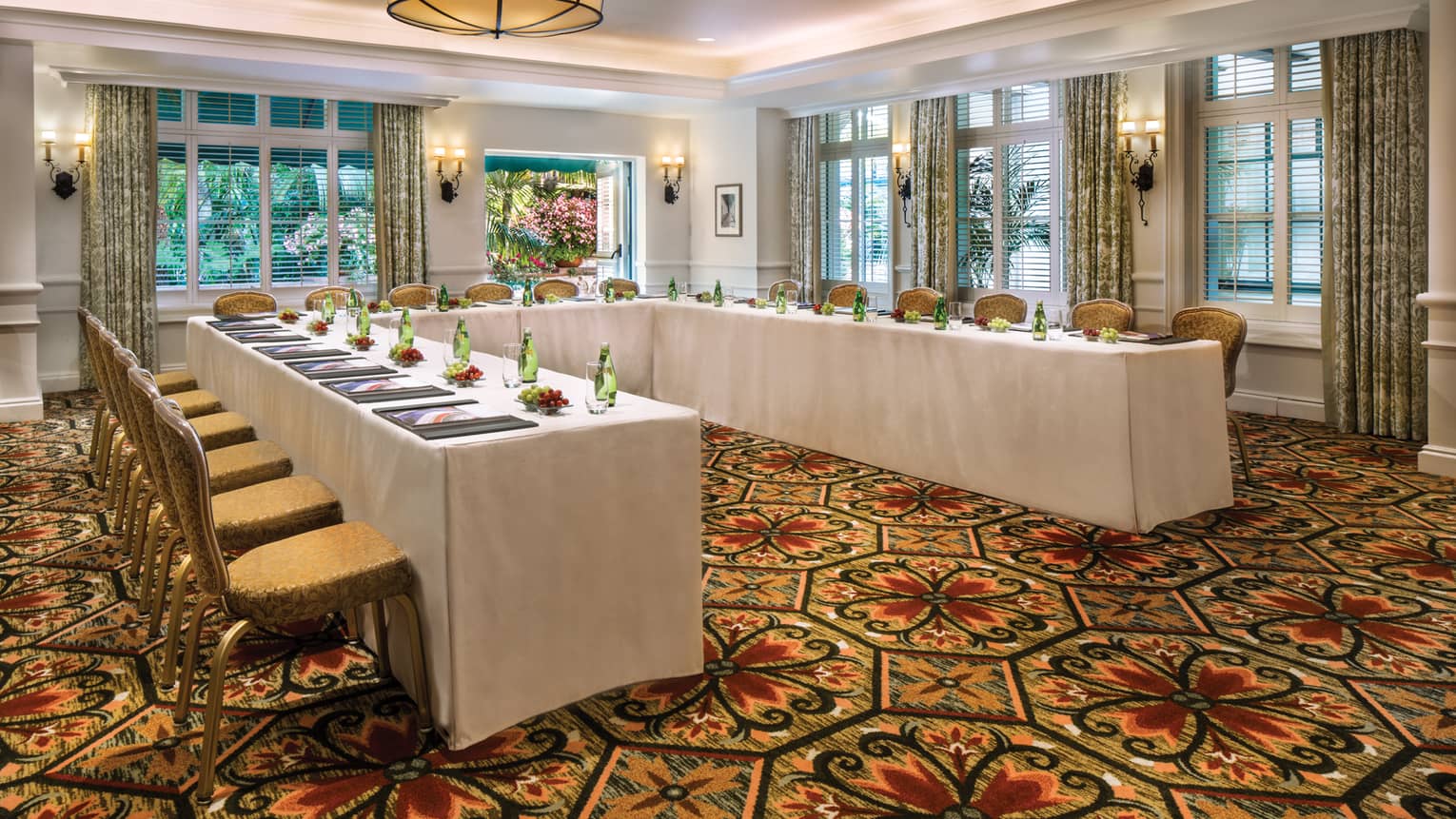 El Jardin carpeted meeting room with modular tables set with water bottles, fresh grapes