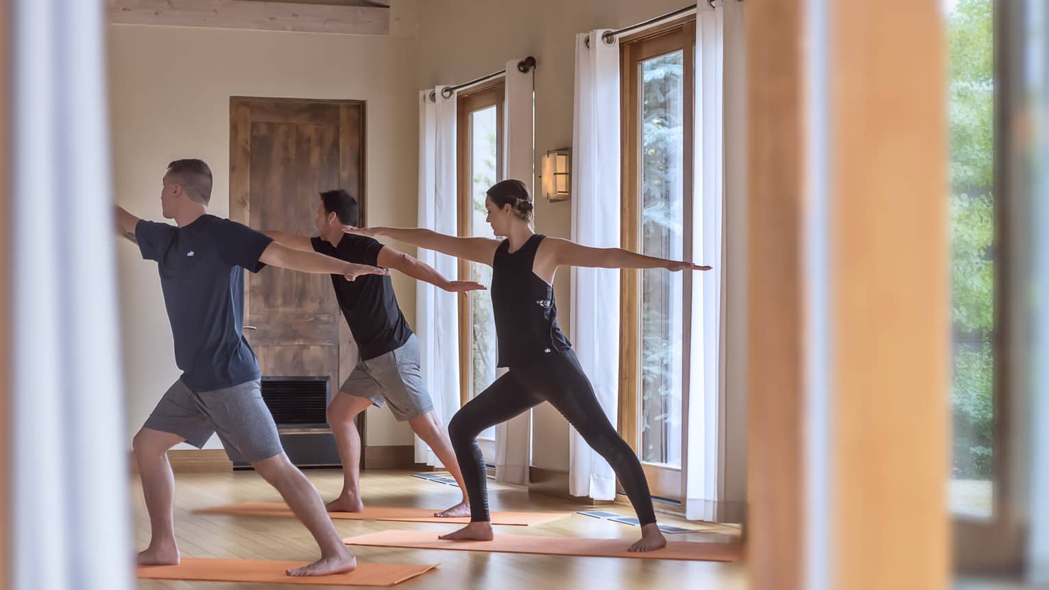 Three people perform yoga pose in Fitness Centre