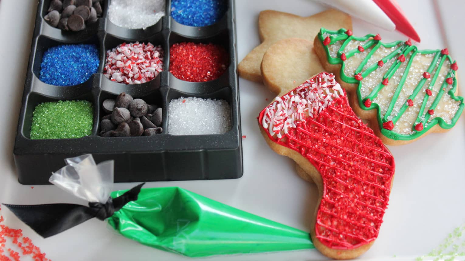 Stocking, christmas free and star-shaped Sugar cookies with sprinkles, icing and chocolate chips next to them 