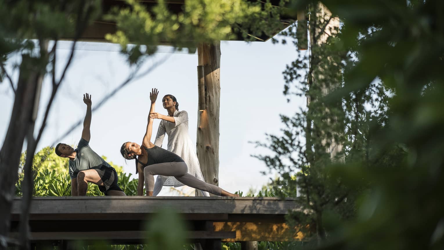Couple stretching during outdoor yoga class