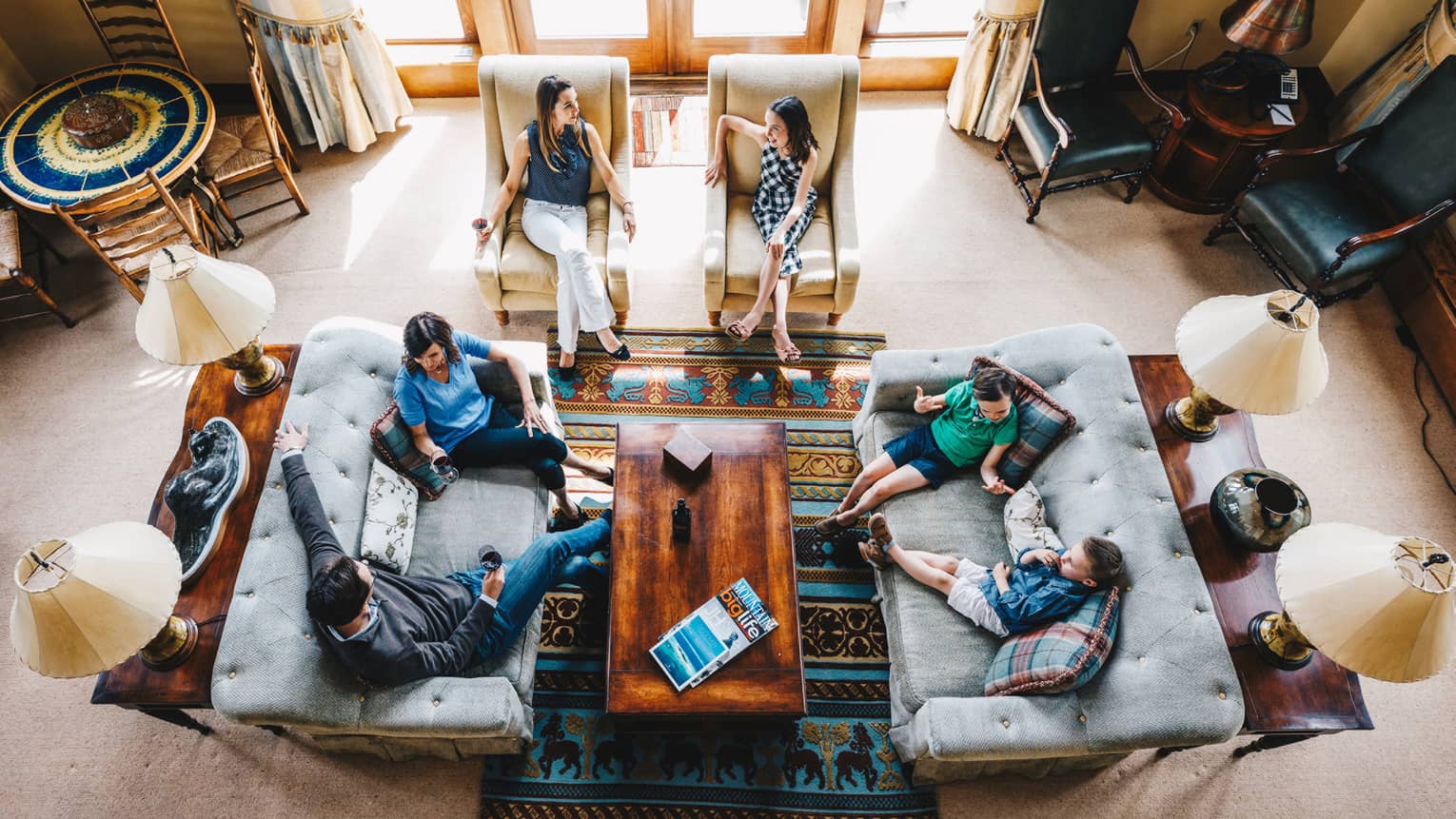Aerial view of guests talking and relaxing in the living room of a residence 