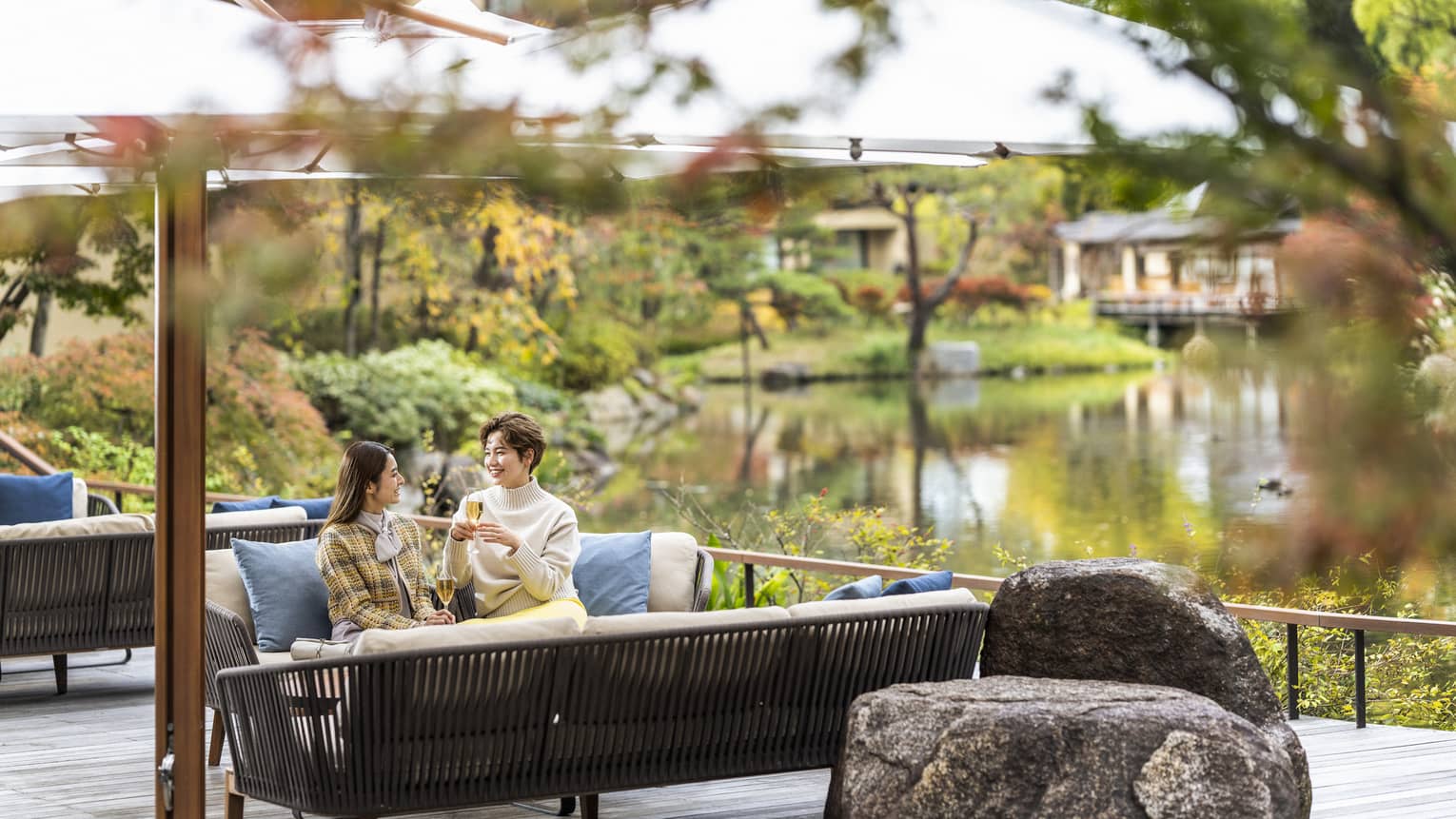 Two women chat on outdoor terrace sofa at Brasserie