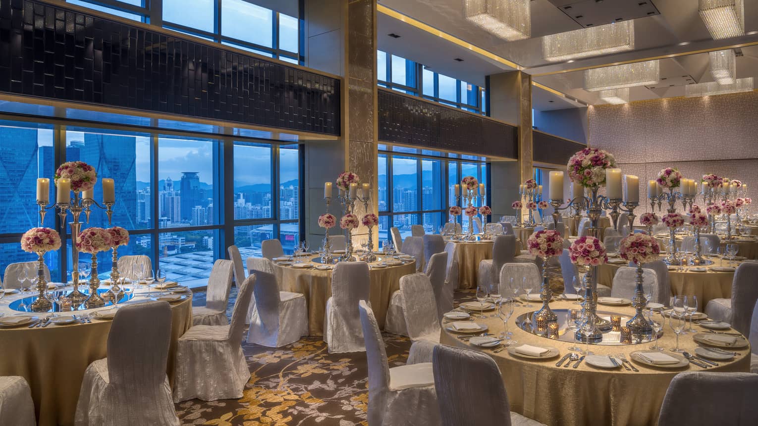 Wedding reception in ballroom, banquet tables with candelabra centrepieces and flowers