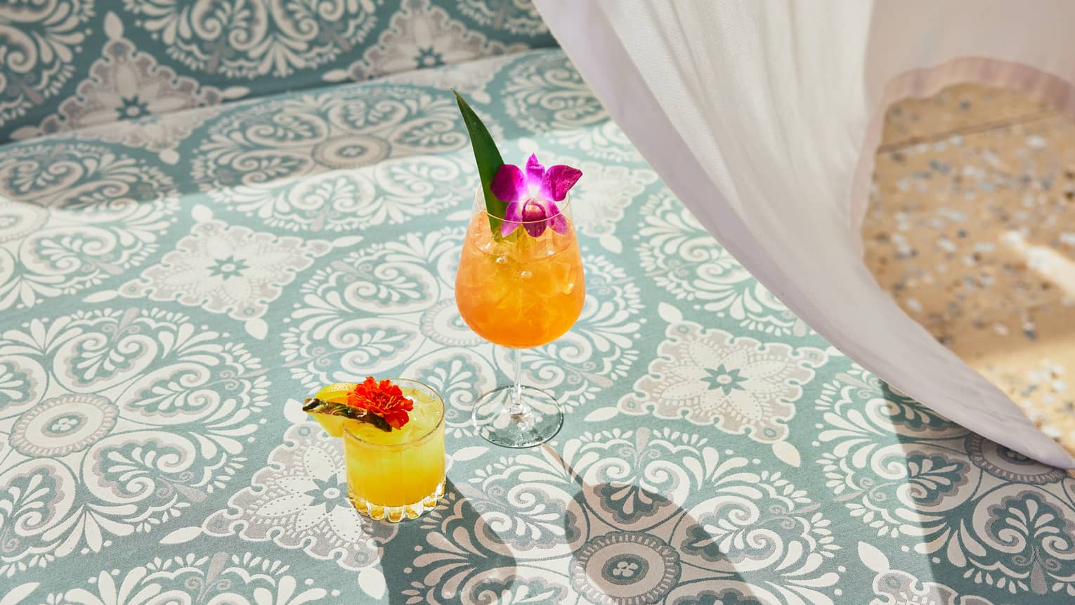 An orange and yellow cocktail on patterned tile.