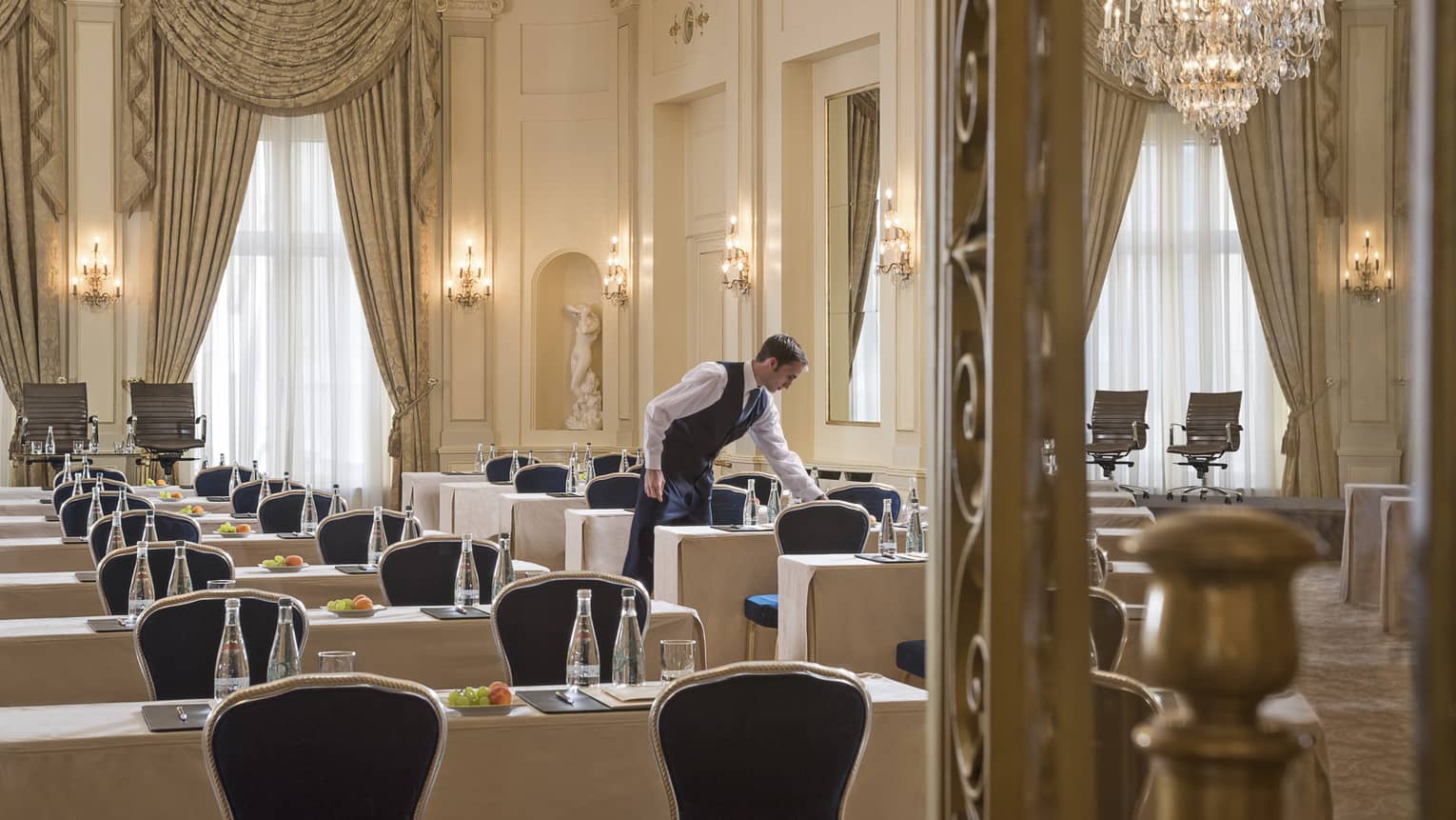 Hotel staff sets rows of conference tables in elegant Salon des Nations