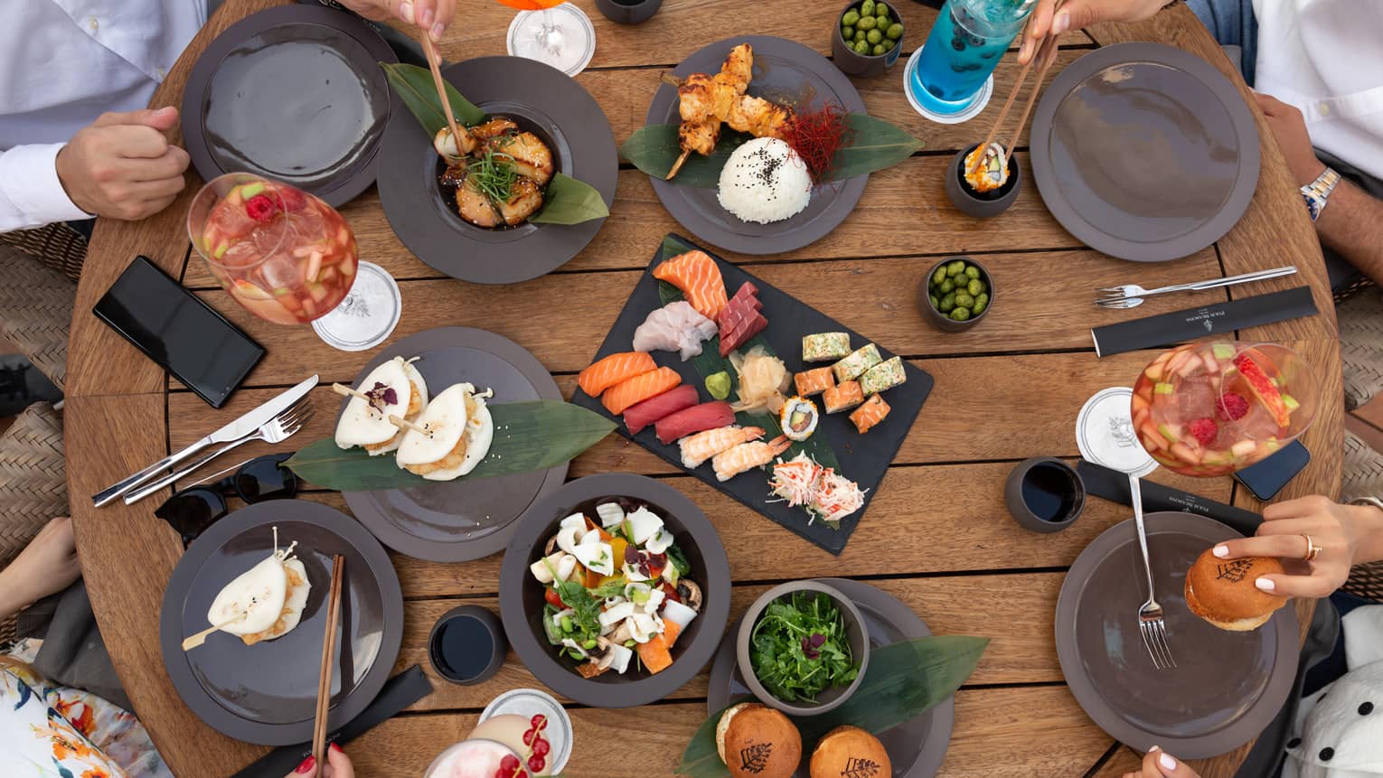 Aerial view of sushi platters, people dining at The Roof Bar and Lounge