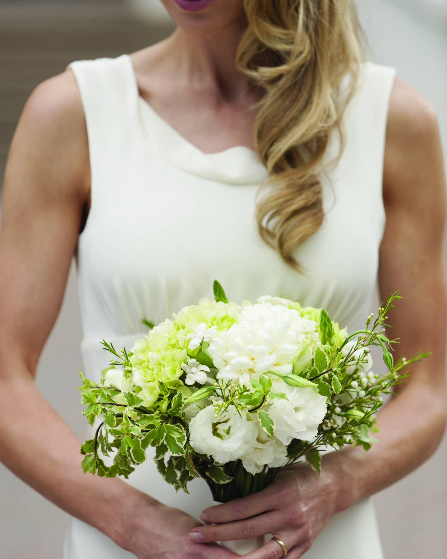 Bride holding white floral wedding bouquet 