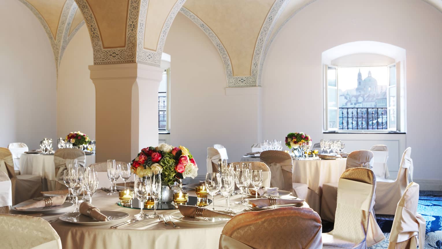 Vltava Meeting Room banquet tables under arched ceiling, sunny windows