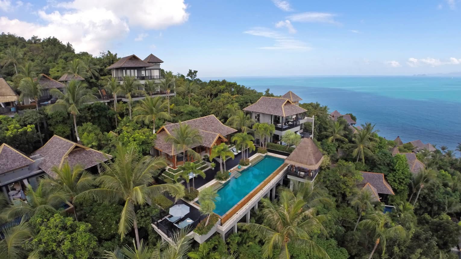 Aerial view of owner's residence villa complex around blue swimming pool, patio on tropical mountain