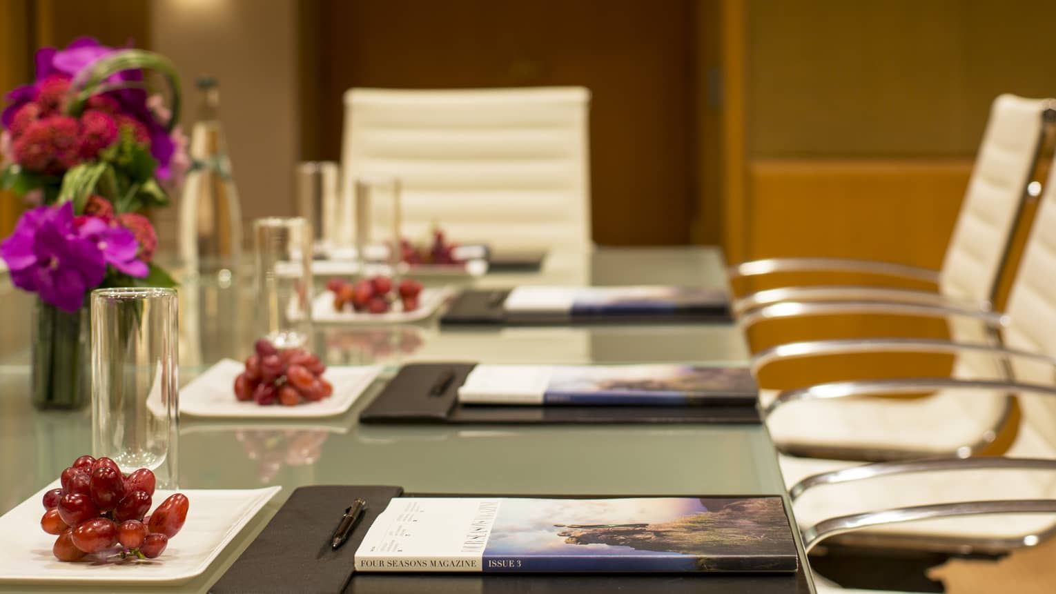 Boardroom meeting table with red grapes on white plates