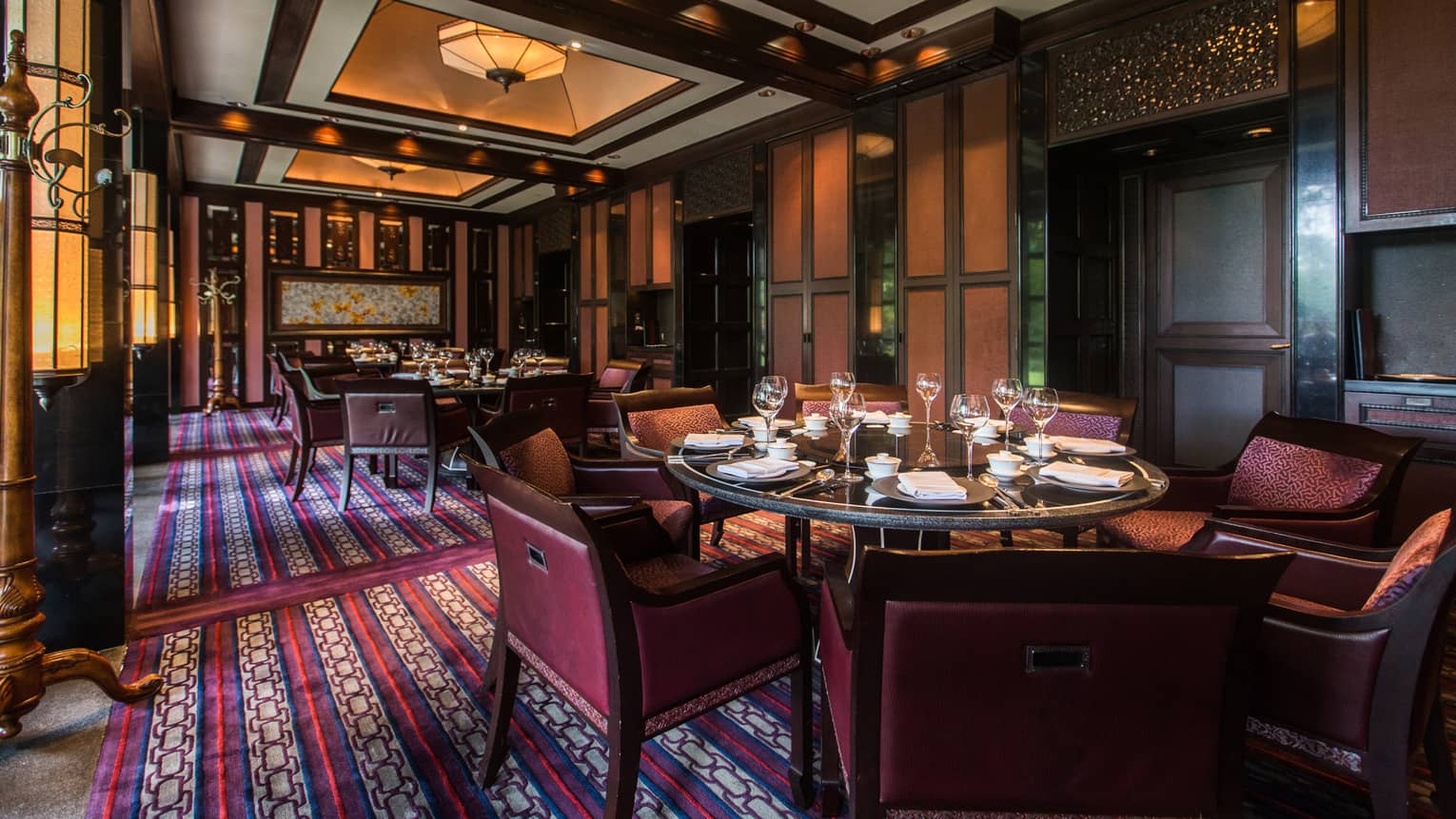 Dining tables, chairs, red-and-blue patterned rug in Jin Sha dining room
