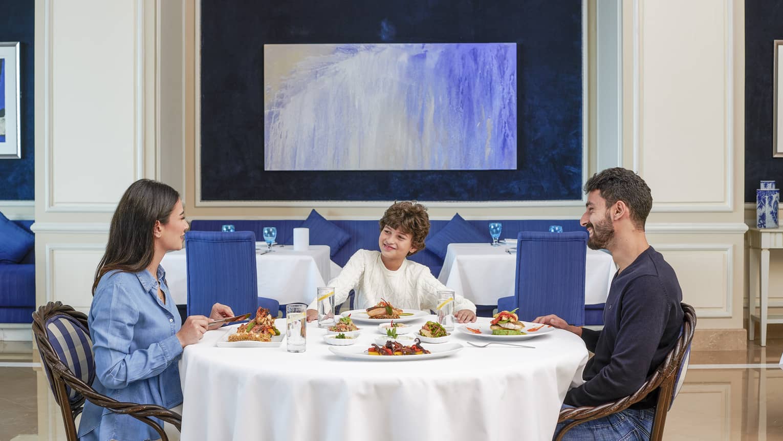 Family of three dines at Kala Restaurant, blue accents