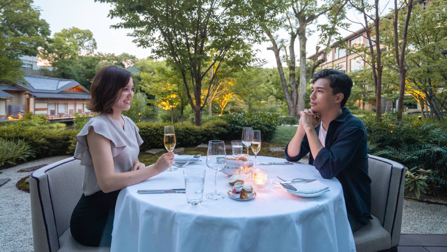 Couple shares romantic dinner outdoors at the pond garden