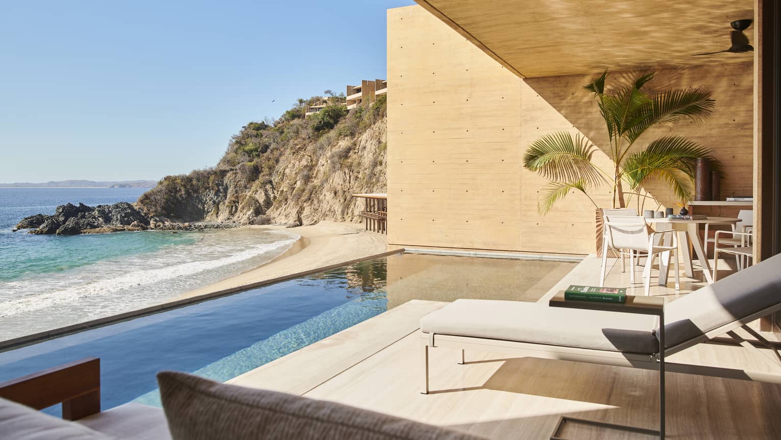 The exterior of a suite with a small pool next to the ocean.