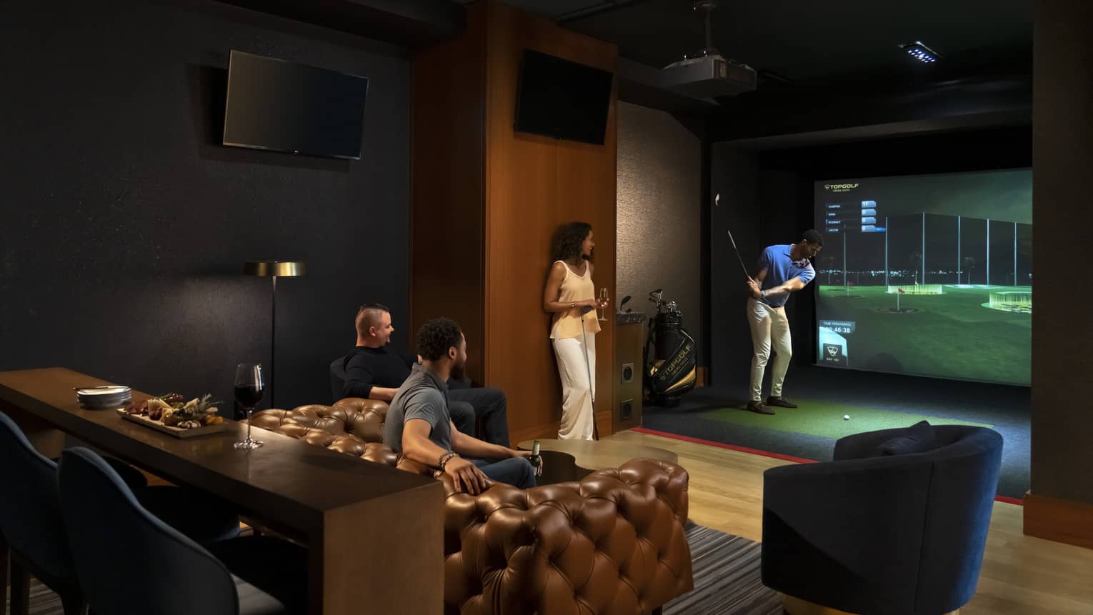A group of people watching and playing a virtual golf game.