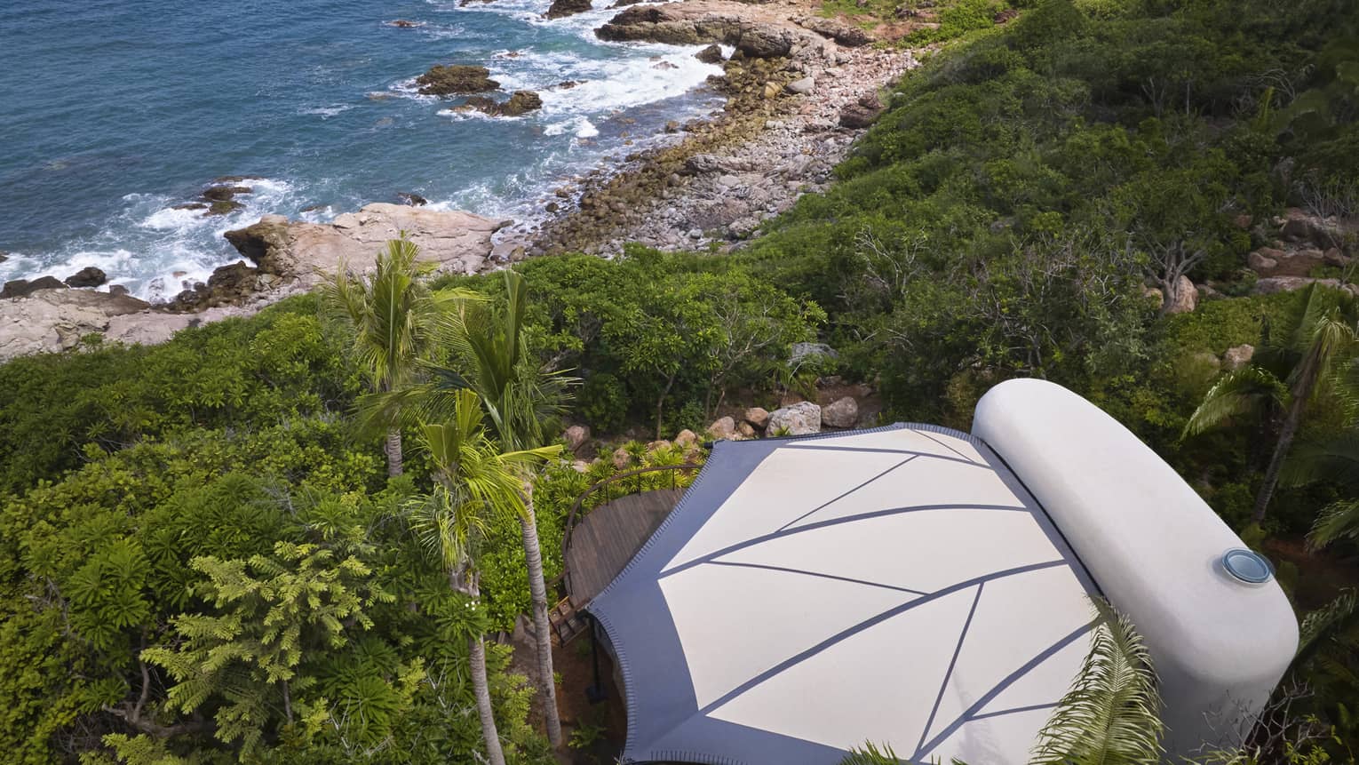 Aerial view of a private luxury tent nestled in the jungle, next to the beach