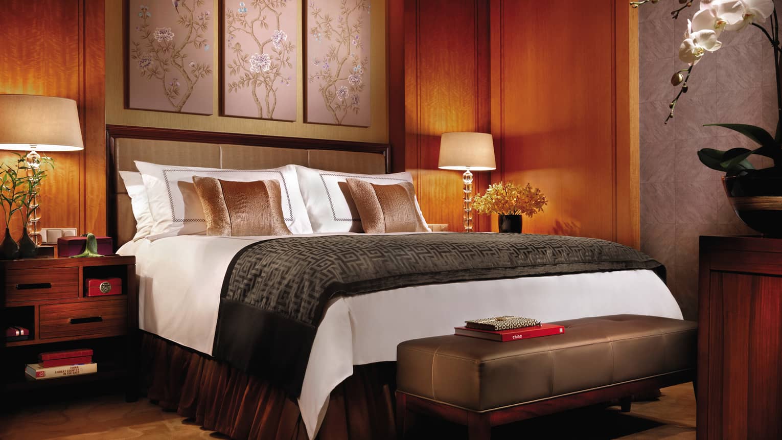 Deluxe Room hotel bed with dark brown, wood decor, traditional Chinese art