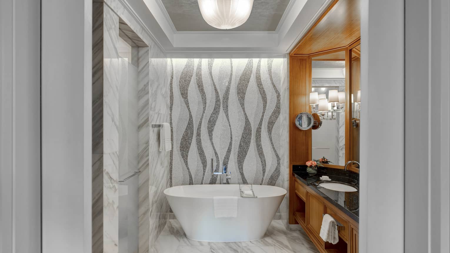 Bathroom with tiled mosaic wall, freestanding tub, vanity