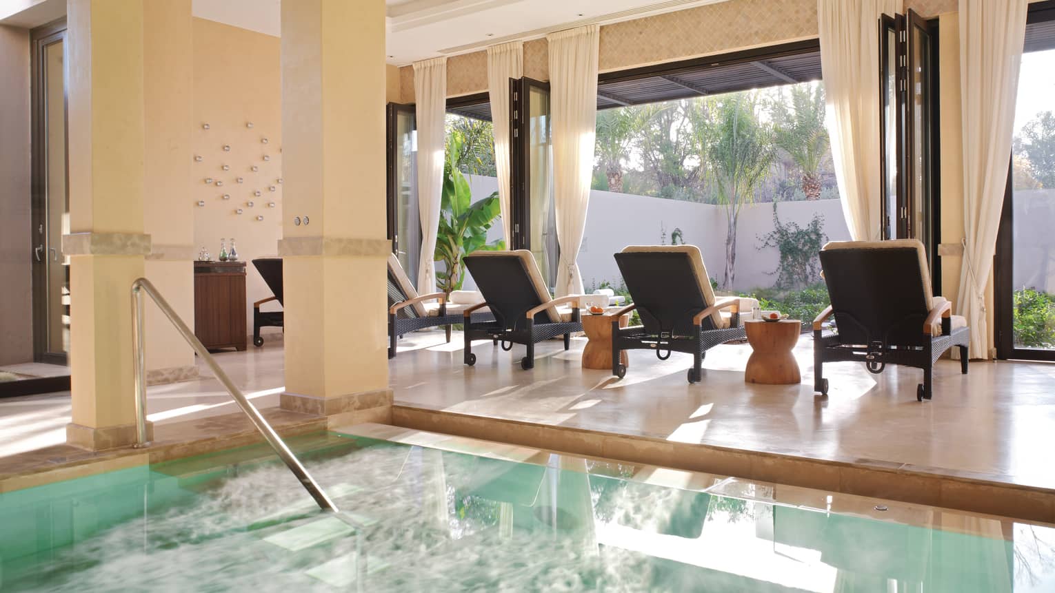 Three lounge chairs at sunny window by steps to Spa plunge pool