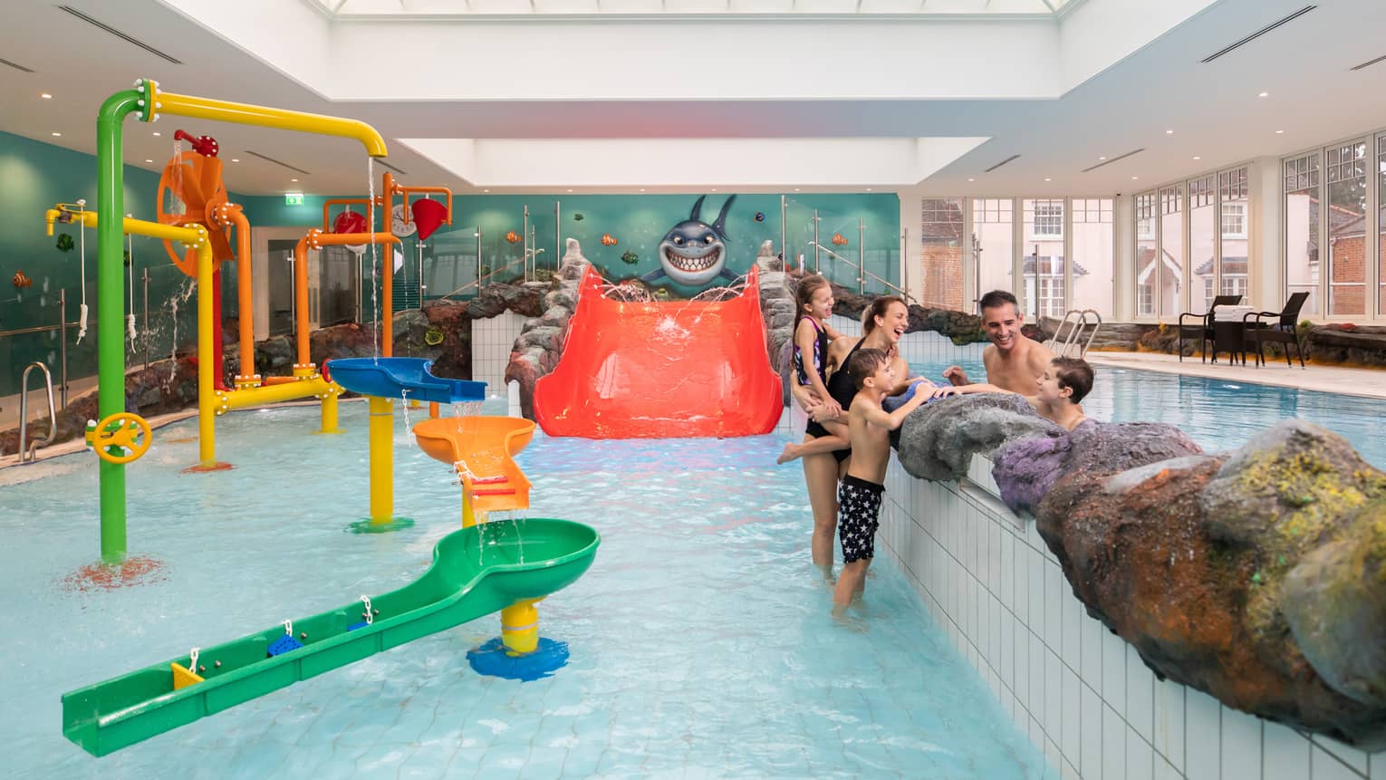 Family talking while standing in Sharkie's colourful indoor pool