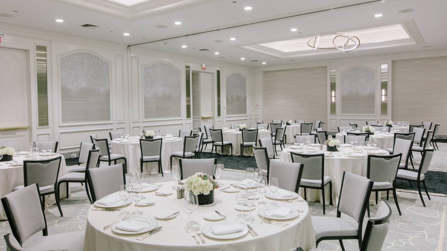 A large room with round tables covered in white cloth.