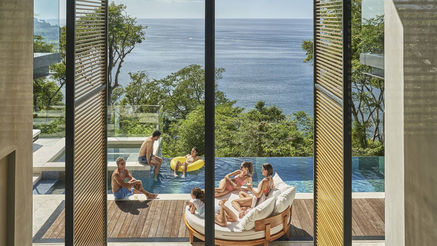 Family in private villa pool with ocean view
