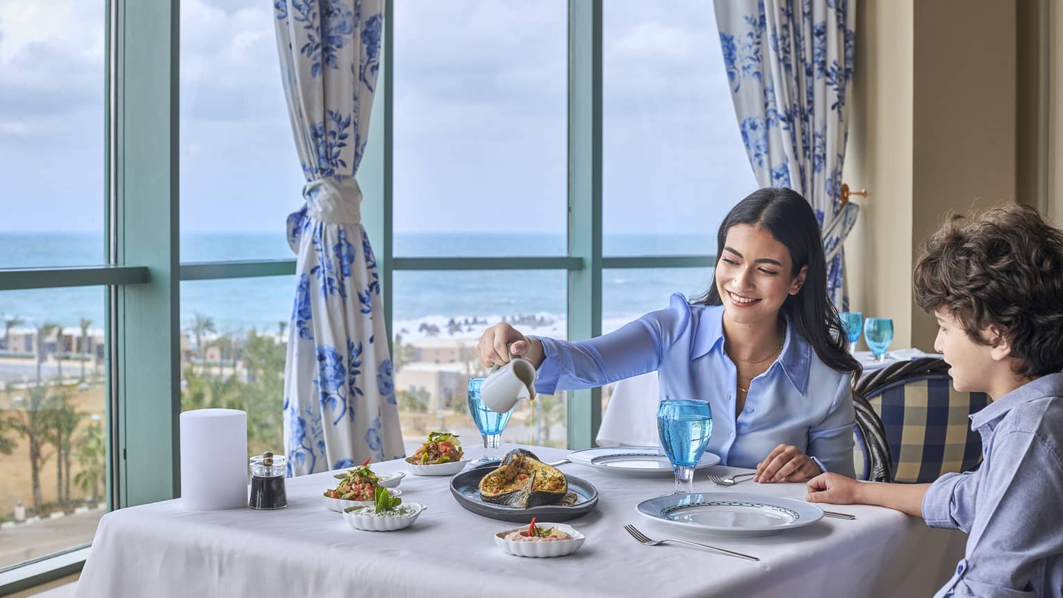 Mother and son enjoy fine dining at Kala Restaurant with views of the Mediterranean Sea
