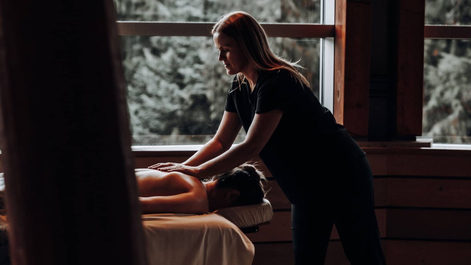 A woman receicing a massage in a dimly lit room.