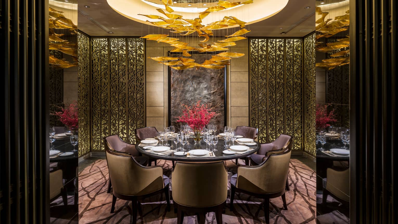 Foo restaurant round dining table in private alcove with decorative gold screens, modern chandelier 
