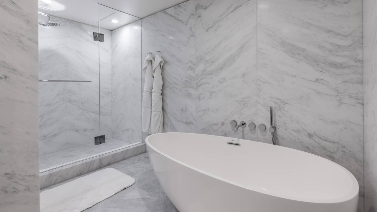 Marble bathroom with freestanding oval tub, walk-in glass shower