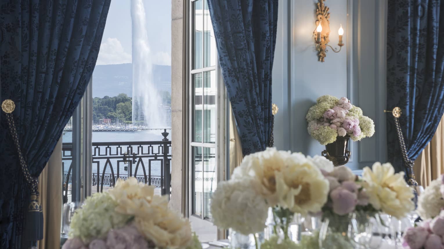 White flowers in Salon Petit Mont Blanc, open door to balcony with fountain view