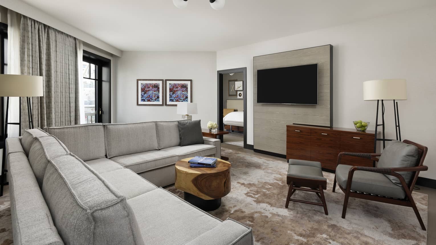 Living area in one bedroom suite with couch, chair, coffee table, and TV