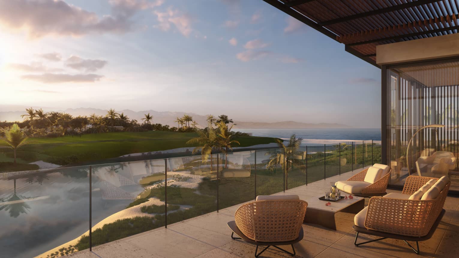 Modern wicker patio furniture by glass balcony overlooking water, green lawns at sunset